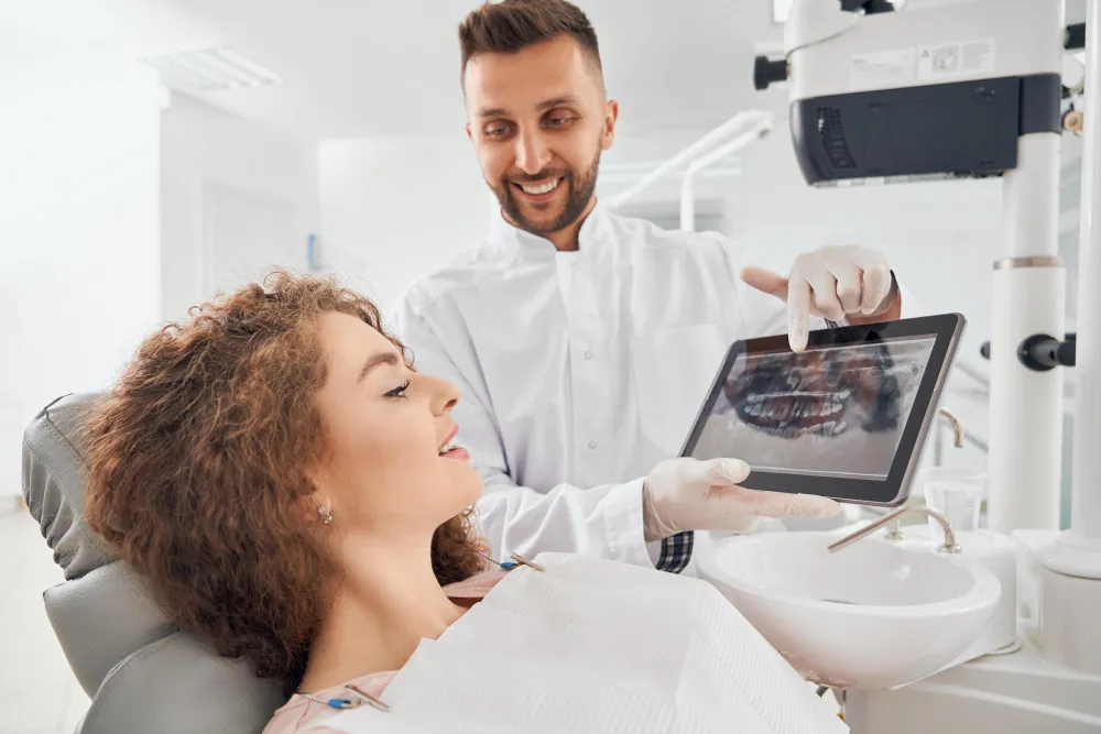 A dentist in clinic examines a patient’s dental X-ray as part of an emergency evaluation.